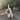 Bottle of white wine on a wooden table with glasses and food in an outdoor setting